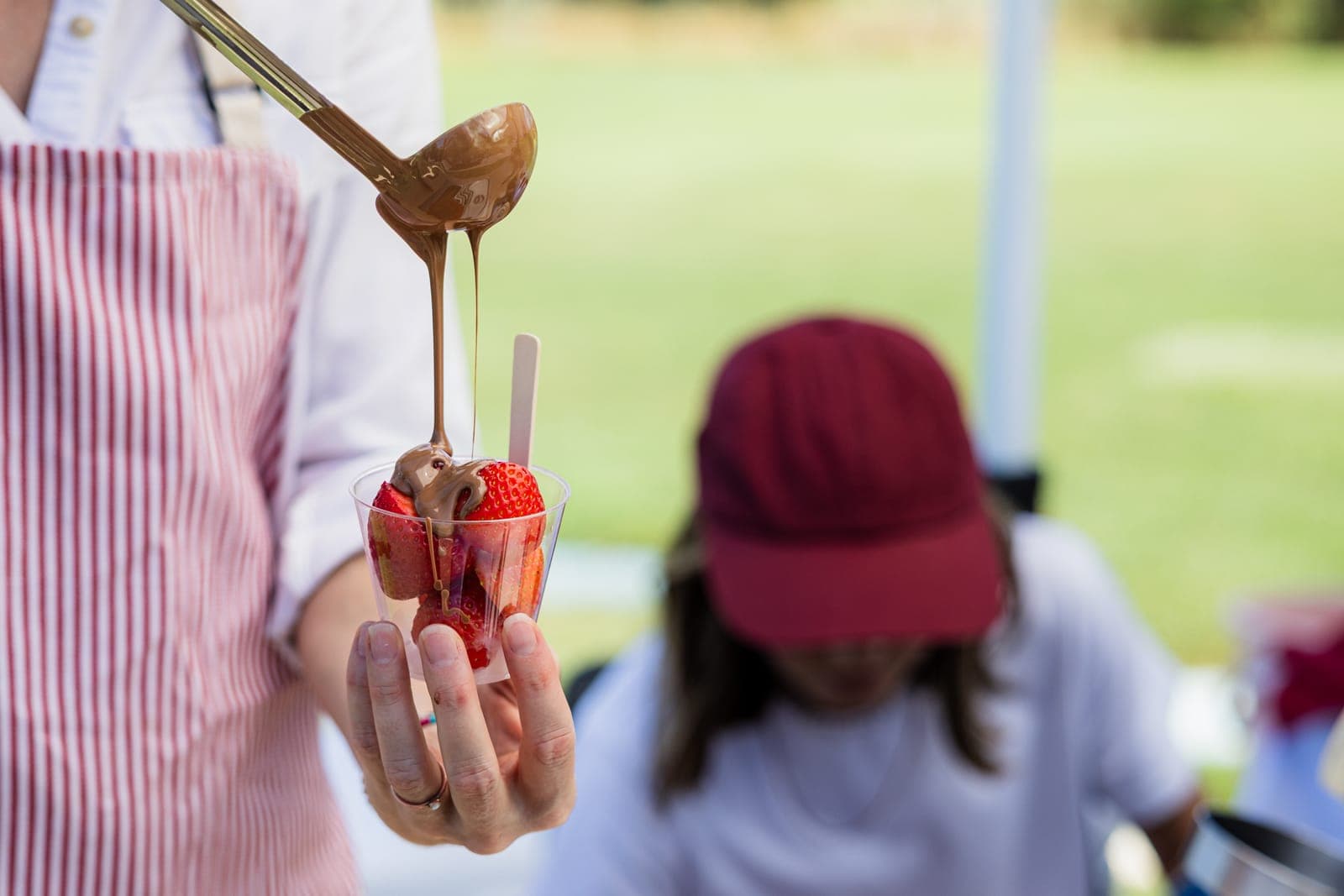 A guest pours melted chocolate over a cup of strawberries at the dessert station at the 2026 Ecom Elevated Invitational.